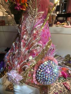 a hat with feathers and jewels on top of a mannequin's head