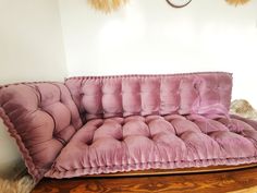 a pink couch sitting on top of a wooden table