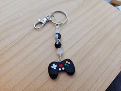 a game controller keychain on a wooden table