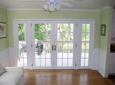 an empty living room with french doors and wood floors