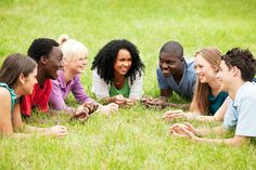 a group of people laying on the ground in a circle and smiling at each other