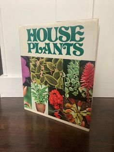 a book on house plants sitting on top of a wooden table