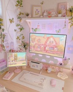 a desk with two computer monitors and a keyboard on it, in front of a pink house