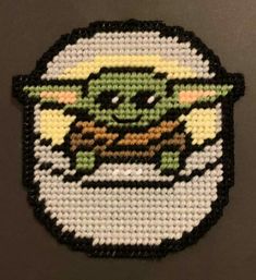 a star wars yoda beaded badge on a black surface with white and green beads