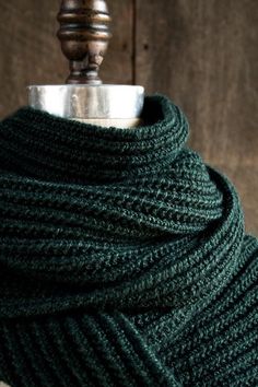 a close up of a green scarf on a mannequin necktie with a metal ring