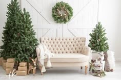 christmas trees and presents in front of a white barn door with wreaths on the wall