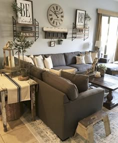 a living room filled with lots of furniture next to a large clock on the wall