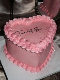 a pink heart shaped cake with the words trust and sir written on it in front of a mirror