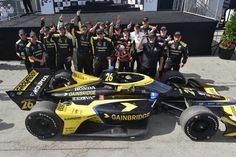 a group of people standing around a racing car