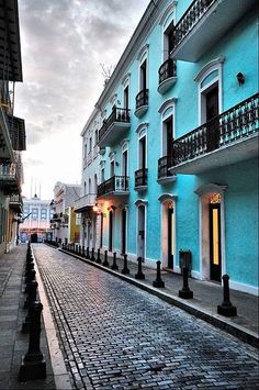 an old san juan street with blue buildings and cobblestone streets in the foreground