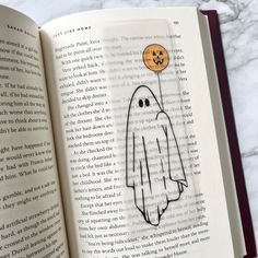 an open book with a drawing of a ghost on it