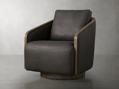 a chair with a wooden frame and grey leather upholstered in the back, sitting on a gray floor