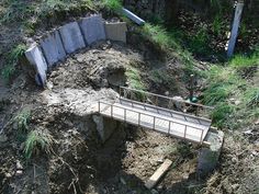 a small wooden bridge over some dirt and grass