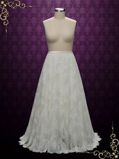 a white wedding dress on display in front of a purple wall with gold ornaments and scrolls