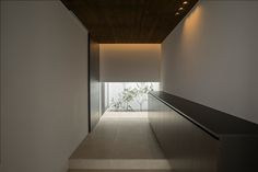 an empty hallway with stairs leading up to the top floor and light coming in from above