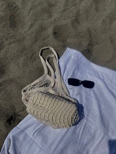 a white towel and sunglasses on the sand