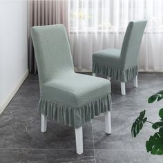 two green chairs with ruffled covers on them