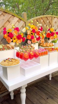 there are many drinks on the table with flowers in vases next to each other