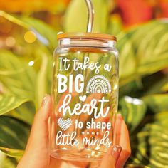 a person holding up a glass with the words it takes a big heart to shape little minds