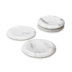 three white marble coasters sitting next to each other