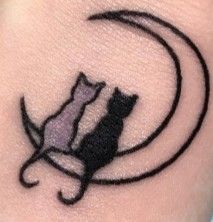 a cat sitting on top of a crescent tattoo