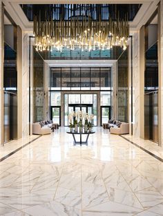 an elegant lobby with chandelier and marble floors, white walls and flooring