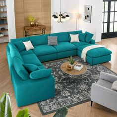 a living room filled with blue couches and pillows on top of a wooden floor