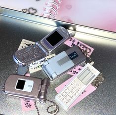 there are many cell phones on top of each other and one has a keychain attached to it