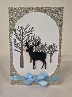 This handmade card captures the magic of winter with a glittering silver forest scene. A graceful reindeer stands in front of shimmering trees, framed by a soft silver background. Topped with a light blue bow, this card is perfect for sending frosty, festive wishes during the holiday season. Included: Comes with a crisp white envelope and a coordinating seal sticker, ready for gifting. Winter Woods Stampin Up Cards, Winter Card Ideas, Yule Cards, Winter Wald, Winter Karten, Holiday Cards Handmade, Winter Woods, Snow Forest, Seal Sticker