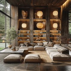 a living room filled with lots of furniture and bookshelves on the wall next to large windows