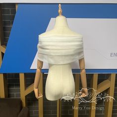 a mannequin's torso is wrapped in white fabric and sits on a wooden stand