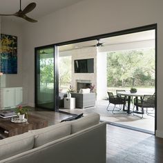 a living room filled with furniture and a fire place in front of a sliding glass door