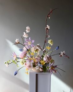 a vase filled with lots of different colored flowers