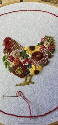 a close up of a embroidery on a piece of cloth with a rooster in the center