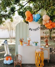 an outdoor dessert table with balloons and decorations