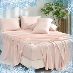 a bed with pink sheets and pillows on top of it in front of snowflakes