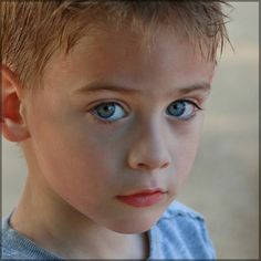 a close up of a young boy with blue eyes