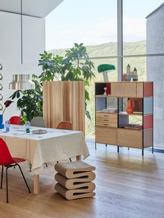 a dining room with a table and chairs next to an open window that looks out onto the countryside