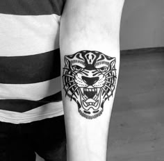 a black and white tiger tattoo on the arm