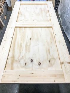 a man standing in front of a table made out of plywood