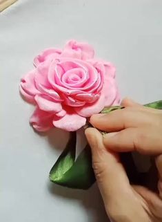 someone is making a pink flower out of fabric