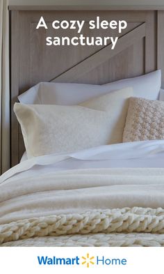 a bed with white pillows and blankets on it