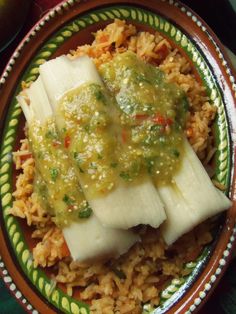 a plate filled with rice and fish covered in sauce