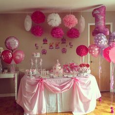 a table topped with lots of pink and white balloons