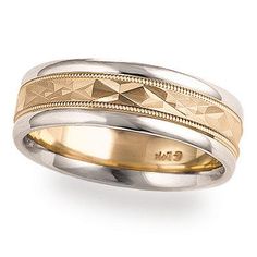 two tone gold and silver wedding ring with an engraved design on the side, set against a white background