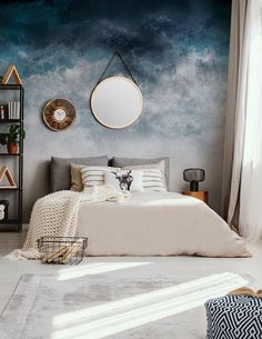 a bedroom with a large bed in front of a blue sky mural on the wall