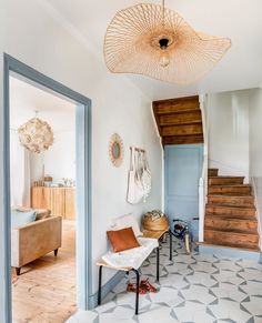 an open door leading to a white room with blue walls and flooring, along with a wooden stair case