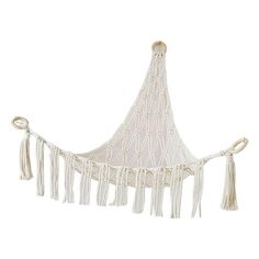 a white hanging hammock with tassels on the sides and fringed ends