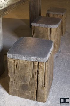 two wooden stools sitting next to each other on top of a cement covered floor