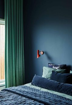 a bedroom with blue walls and green curtains